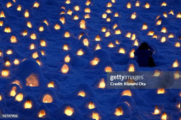Visitor takes pictures of the candlelit miniature Kamakura, or snow huts, along the river bank during the Kamakura Snow Festival on February 15, 2010...