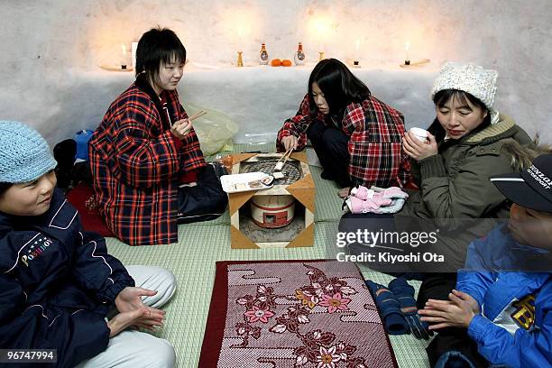 Children and visitors sit in Kamakura, or a snow hut, during the Kamakura Snow Festival on February 16, 2010 in Yokote, Akita, Japan. In the...