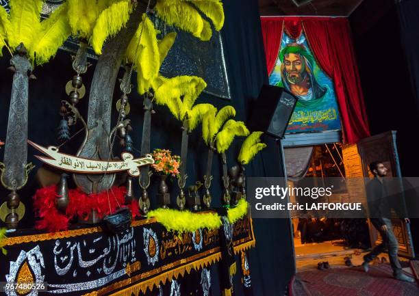 An alam near an imam hussein portrait on ashura, isfahan province, kashan, Iran on October 20, 2015 in Kashan, Iran.