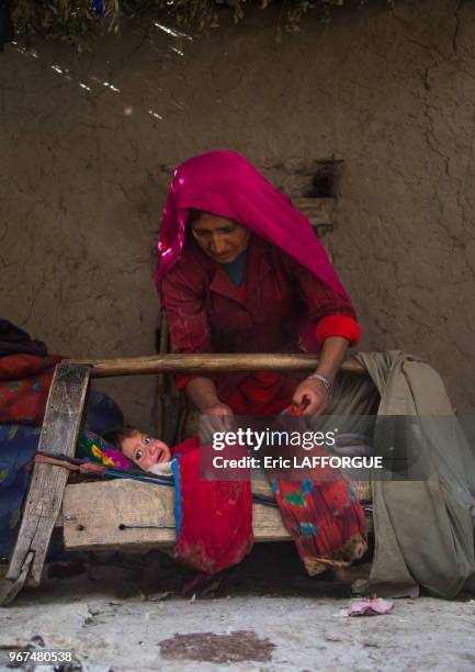 Mother looking after her baby in a craddle, Badakhshan province, Qazi deh, Afghanistan.