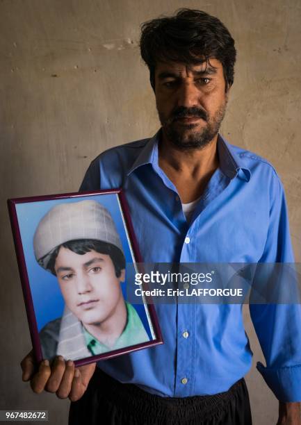 An afghan refugee man showing a portrait of himself when he was a teenager, isfahan province, kashan, Iran on October 21, 2015 in Kashan, Iran.