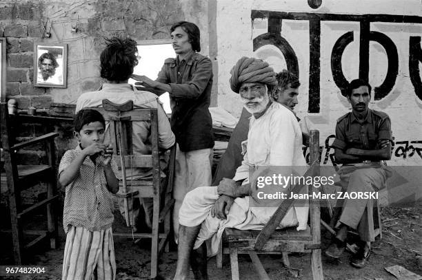 Scène de vie quotidienne dans l'échoppe d'un coiffeur, le 28 novembre 1982 à Pushkar, Rajasthan, Inde.