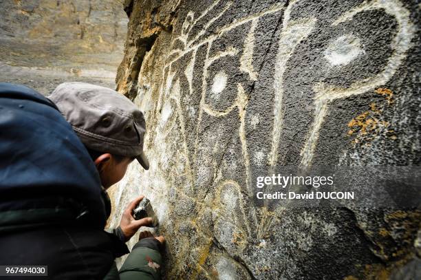 Nepal, Le Haut-Dolpo, Kora de la montagne de cristal, pres de Shey, homme grave un rocher.