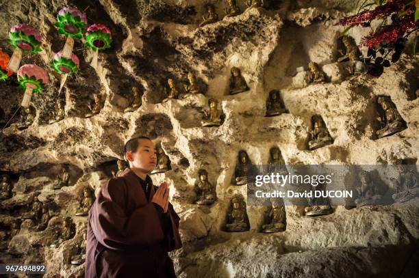 Young monk praying at Golgul temple and Sunmodo center near Gyeongju city, Gyeongsangbuk province, South Korea.