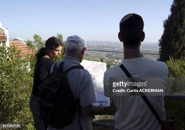 April 28 2005. A settler couple and her father look at the view while comparing the map in Homesh, a West Bank settlement. Homesh is among those...