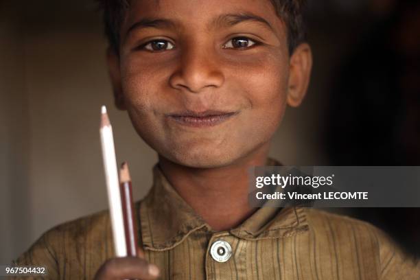 Enfant indien brandissant ses crayons de couleur lors d?un cours de dessin donné par une ONG locale à des enfants défavorisés à Udaipur, dans l'état...