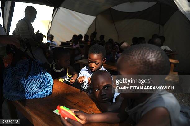 Haitian children receive a lesson inside a tent at the courtyard of a religious school in the heart of Petion-ville, in the heights of the Haitian...