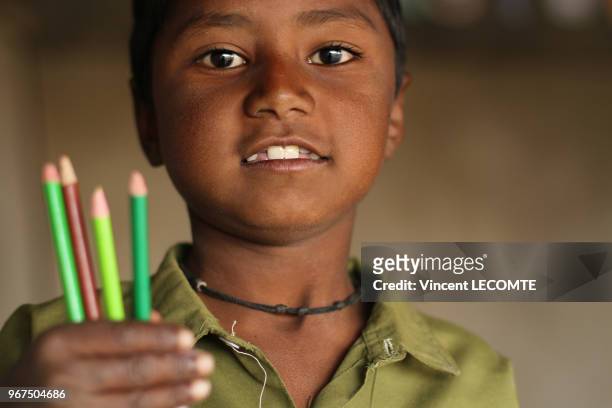 Enfant indien brandissant ses crayons de couleur lors d?un cours de dessin donné par une ONG locale à des enfants défavorisés à Udaipur, dans l'état...