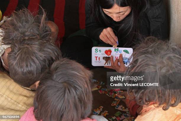 Une bénévole montre un abécédaire à des enfants indiens lors d?un cours d?alphabétisation donné par une ONG locale à des enfants défavorisés à...