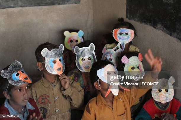 Elèves indiens portant des masques d'animaux confectionnés en classe lors d?une activité pédagogique proposée par une ONG locale à des enfants...