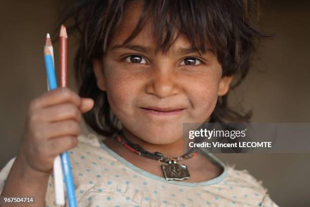 Enfant indien brandissant ses crayons de couleur lors d?un cours de dessin donné par une ONG locale à des enfants défavorisés à Udaipur, dans l'état...