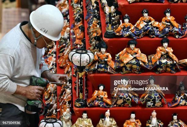 Installation de poupées sur une estrade en pyramide de 7m de hauteur pour se préparer à la "Hina matsuri" dans un grand magasin de la ville de Konosu...