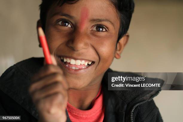 Enfant indien brandissant un crayon de couleur lors d?un cours de dessin donné par une ONG locale à des enfants défavorisés à Udaipur, dans l'état du...