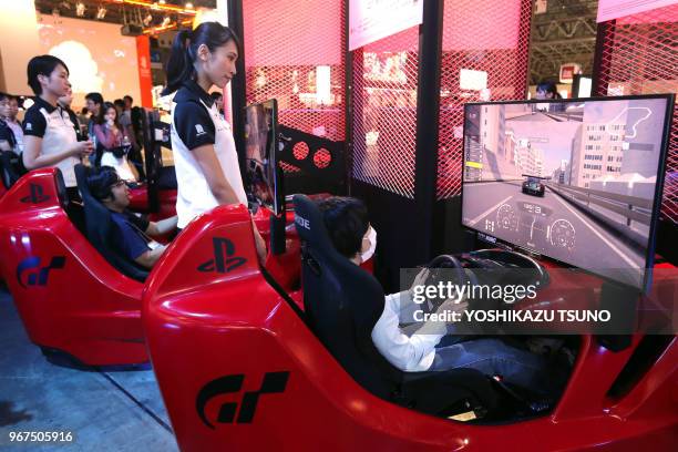 Visitors try to play videogame with Sony Interactive Entertainment's PlayStation 4 at the annual Tokyo Game Show in Chiba, suburban Tokyo on...