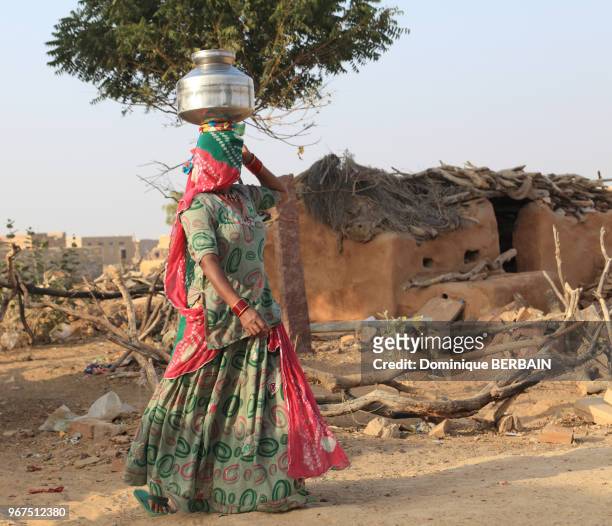 Jeune femme indienne transportant de l'eau sur un pot posé sur sa tête, 31 décembre 2016, Jaisalmer, Rajasthan, Inde.