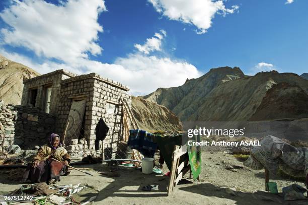 India, Ladakh, Markha Valley, old woman with ripples in front of typical ladakhi house.