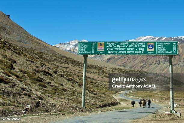 India, Ladakh, scenic landscape with man walking on the road in the Himalayas.