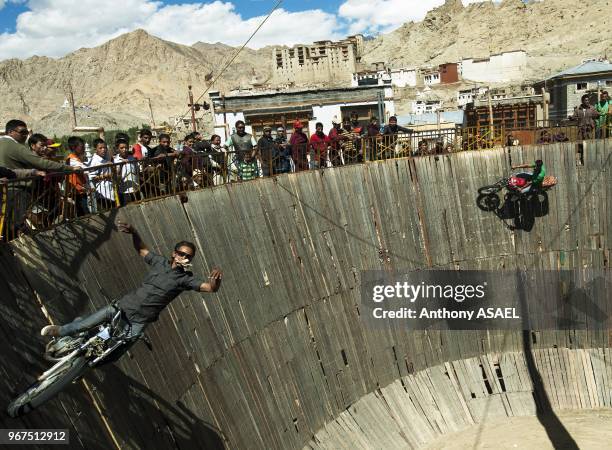 India, Ladakh, Leh, tibetan circus fair with stunt man going vertical with car and motorcycle.