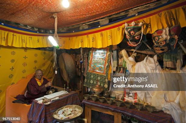 India, Ladakh, Hemis, monk praying inside Hemis Monastery constructed out of wood.