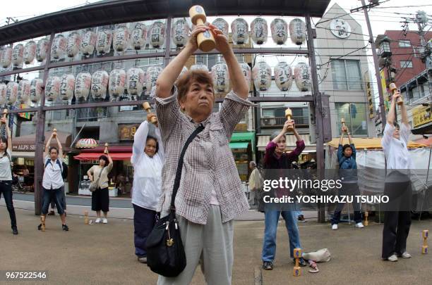 Personnes âgées faisant des exercices physiques avec des haltères de bois dans un temple à Tokyo le 19 septembre 2016, pour célébrer le 'Respect for...