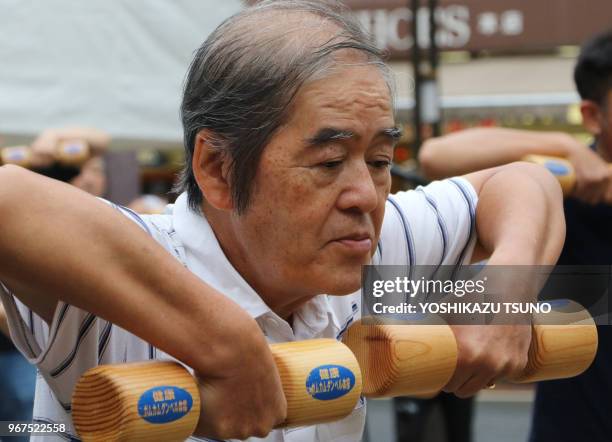 Personnes âgées faisant des exercices physiques avec des haltères de bois dans un temple à Tokyo le 19 septembre 2016, pour célébrer le 'Respect for...