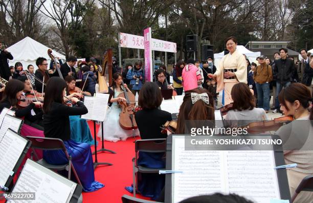 Une femme en kimono dirige un orchestre de 40 musiciens au parc Ueno à Tokyo le 31 mars 2017 lors du 'Tokyo Spring Festival - Tokyo 0pera Nomor',...
