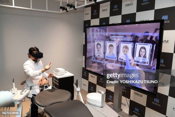 Japanese dentist wearing a head mount display demonstrates a dental treatment on a dammy using a technology of mexed reality in Tokyo on April 21,...