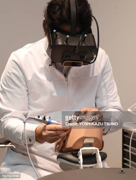 Japanese dentist wearing a head mount display demonstrates a dental treatment on a dammy using a technology of mexed reality in Tokyo on April 21,...