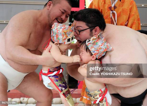 Bébés tenus par des lutteurs sumo s'affrontent en criant le plus fort possible dans le temple d'Irugi à Tokyo le 18 septembre 2016, Japon. Les...