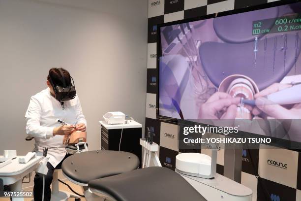 Japanese dentist wearing a head mount display demonstrates a dental treatment on a dammy using a technology of mexed reality in Tokyo on April 21,...