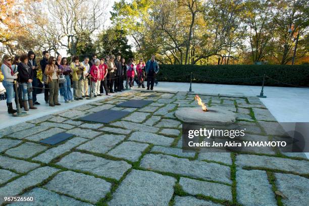 Visiteurs devant la flamme éternelle de la tombe de John F. Kennedy au cimetière national d'Arlington, Virginie, Etats-Unis.