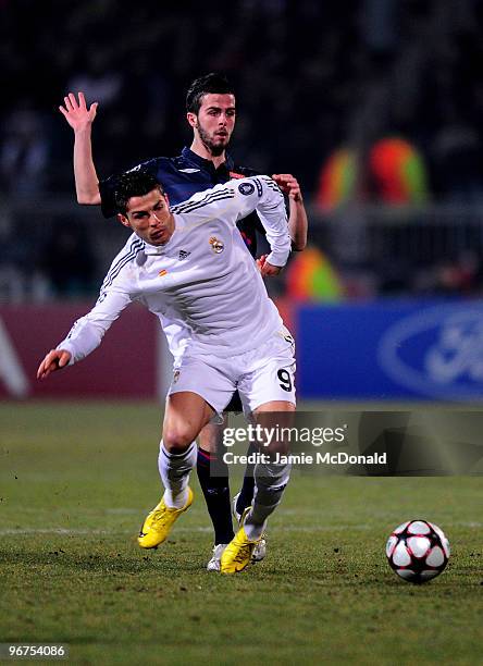 Cristiano Ronaldo of Real Madrid is tackled by Miralem Pjanic of Lyon during the UEFA Champions League round of 16 first leg match between Lyon and...