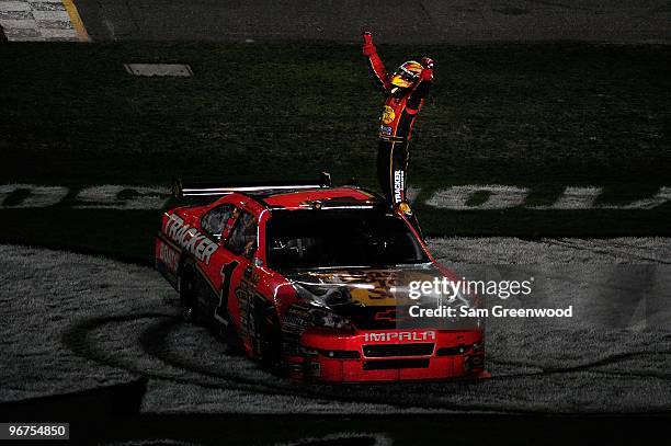 Jamie McMurray climbs on top of his Bass Tracker Chevrolet to celebrate winning the NASCAR Sprint Cup Series Daytona 500 at Daytona International...