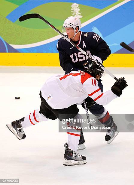 Ryan Suter of The United States battles for the puck with Roman Wick of Switzerland during the ice hockey men's preliminary on day 5 of the Vancouver...