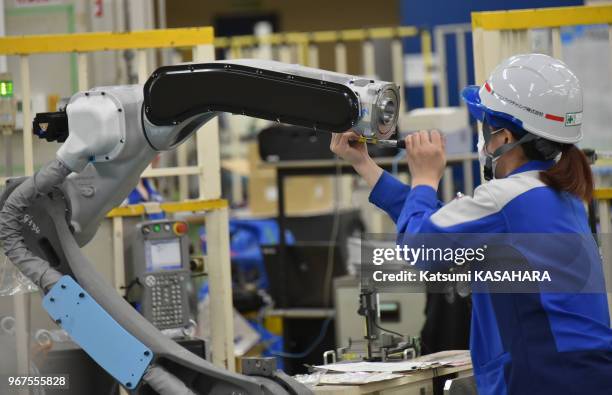 Woman technician checkes a robot arm at the final assembly line in Yaskawa Electric's head factory in Kitakyushu, March 18 Japon.