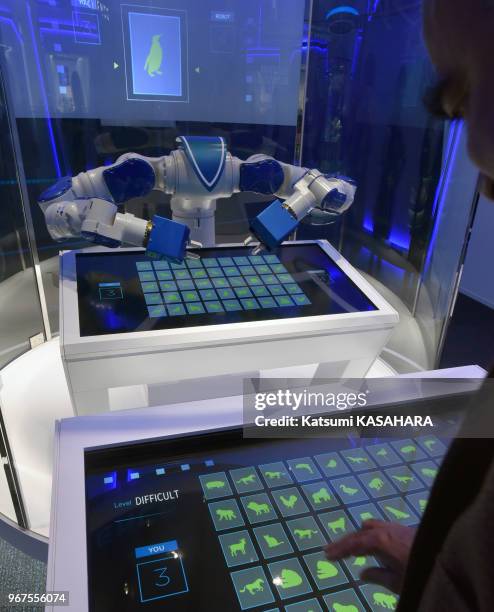 Un robot joue aux cartes avec un visiteur dans le show room de la société Yaskawa Electric, 20 mars 2016, Kitakyushu, Japon.