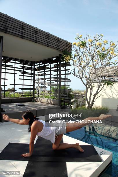 Une touriste asiatique prenant un cours de yoga privé au sein de son hôtel le 27 septembre 2014, Bali, Indonésie.