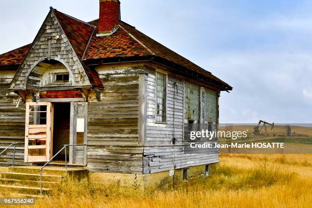 Maison abandonne?e et pompe Jumping Jack en arrie?re plan, 22 octobre 2013, près de Williston, Dakota du Nord, Etats-Unis.