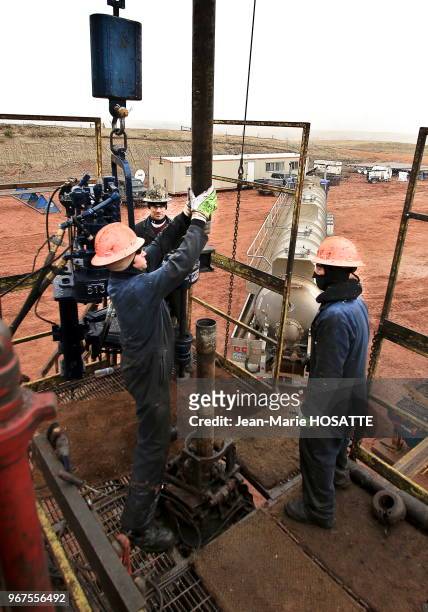 Ouvriers fixant des tuyaux sur la plateforme pétrolière, 21 octobre 2013, près de Williston, Dakota du Nord, Etats-Unis.