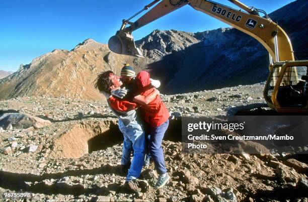 Three workers celebrate after having discovered a new strand of the precious Lapis Lazuli stone in the Flores de Los Andes mine, located at 3,700...