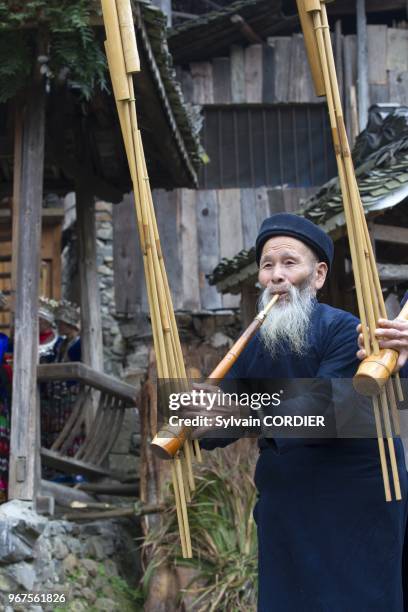 Chine, province du Guizhou, village de Langde, ethnie des Long Skirt Miao en habits traditionnels, les hommes jouent du lusheng . China, Guizhou...