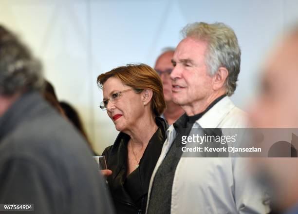 Anette Bening and Warren Beatty listen to George Stevens, Jr., filmmaker and founder of the American Film Institute, speak during a reception in...