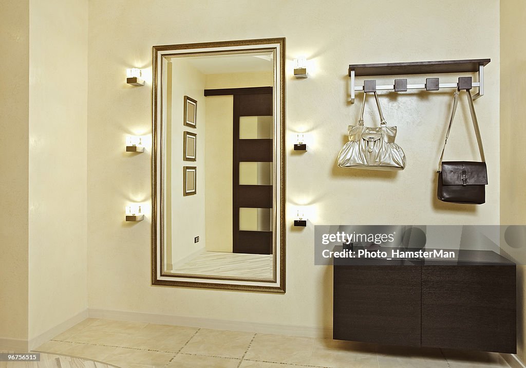 Hall in beige tones with hall-stand and golden mirror