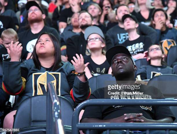 Vegas Golden Knights fans stare up at the scoreboard showing the game after a first-period goal by Tom Wilson of the Washington Capitals against the...