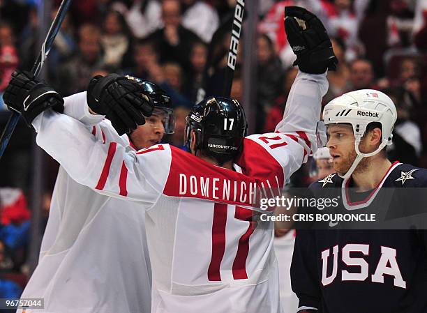 Switzerland's Hnat Domenichelli celebrates a goal with a teammate during the Men's Ice Hockey preliminary game between USA and Switzerland at the...