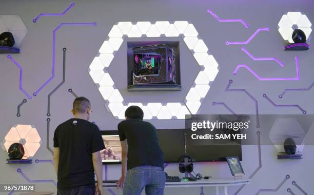 Two technicians work at the Asus music booth during Computex 2018 at the Nangang Exhibition Center in Taipei on June 5, 2018.