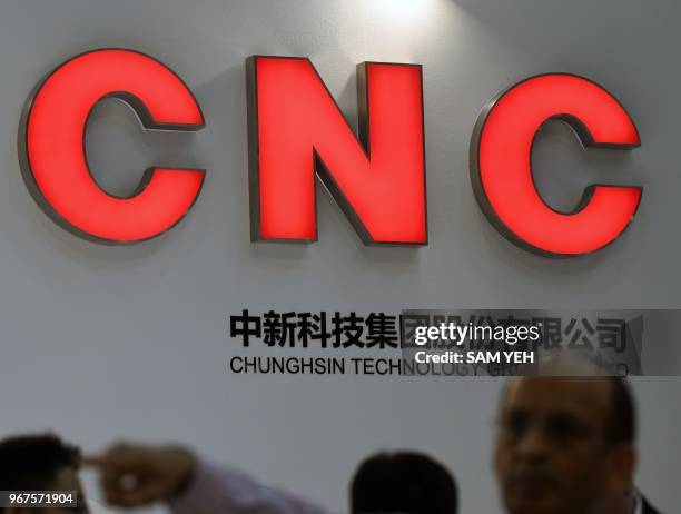 Visitors stand in front of a Chunghsin Technology logo during Computex 2018 at the Nangang Exhibition Center in Taipei on June 5, 2018.