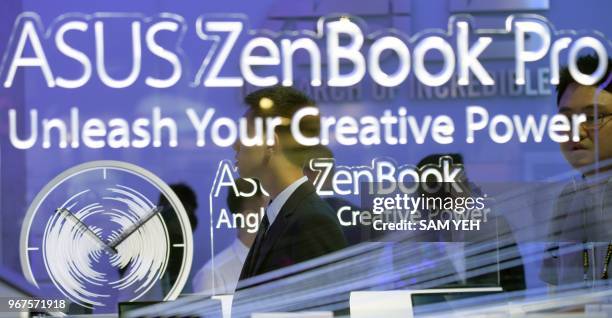 An visitor walks pass a logo of Asus Zenbook during Computex 2018 at the Nangang Exhibition Center in Taipei on June 5, 2018.