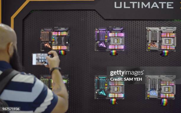 An visitor takes a picture of the decorated LED computer motherboards during Computex 2018 at the Nangang Exhibition Center in Taipei on June 5, 2018.