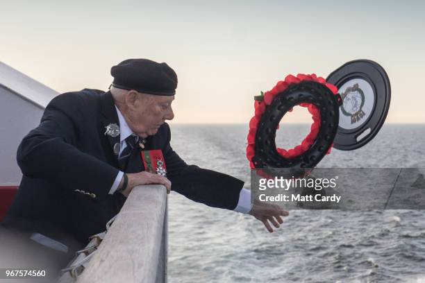 John Quinn, Royal Marine who was a coxswain on a landing craft that landed on Gold Beach on D-Day throws a wreath into the sea as Normandy veterans...